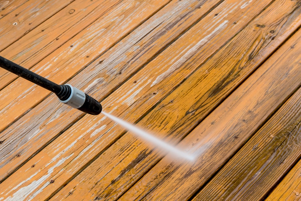 DIYer pressure washing wooden deck