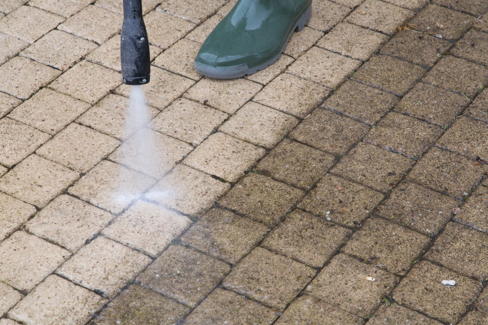 DIYer pressure washing their sidewalk